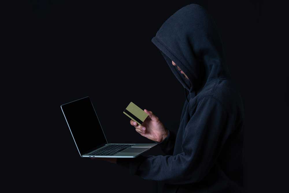 hacker holding credit card, learn how to protect customers from theft