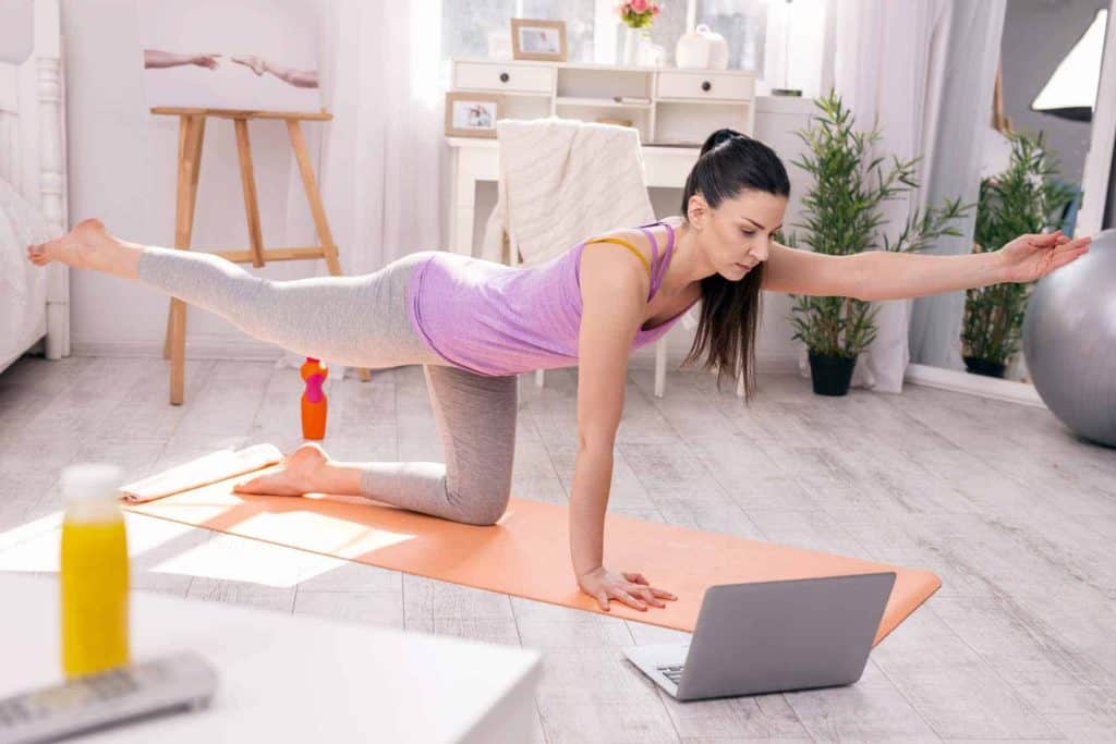 woman doing yoga via virtual exercise classes